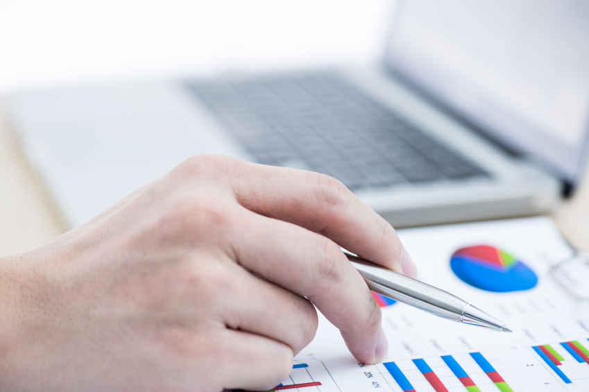 Businessman analyzing investment charts with laptop